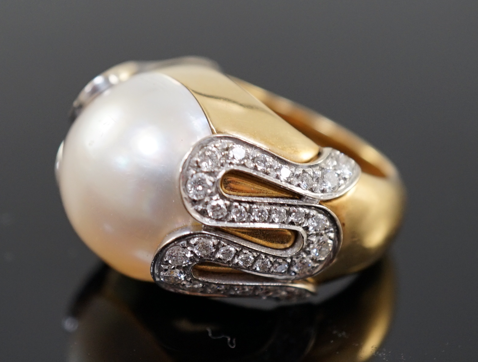 A modern Italian Versace 18ct gold and half cultured pearl set dress ring, with round brilliant cut diamond set shoulders